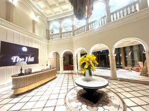 a lobby with a vase of yellow flowers on a table at Diamond Suite The Hill Phu Quoc in Phú Quốc