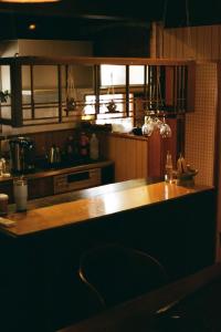 a kitchen with a wooden counter top and a sink at ましこのま- 明治の建物をリノベした街中ローカルステイ in Mashiko +14 photos