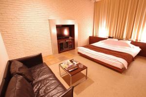 札幌市にあるブルーホテル オクタ (大人専用)のベッドルーム1室(ベッド1台、ソファ、テーブル付)