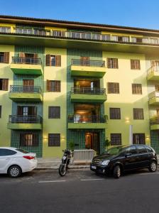 a building with cars parked in front of it at Roupa cama Wi-Fi garagem ar Cond beira mar 50 m in Tramandaí