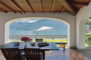 a dining room table with a view of the water at Villa Bianca - Front Lake Pool by Rent All Como in Sala Comacina