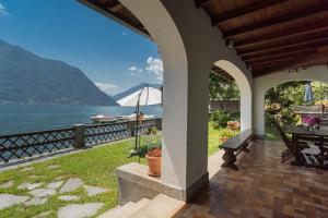 a porch of a house with a view of the water at Villa Bianca - Front Lake Pool by Rent All Como in Sala Comacina
