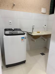 a small kitchen with a sink and a refrigerator at Apto Mais Decor 02 in Salinas +5 photos