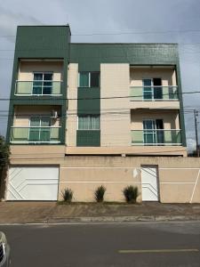 an apartment building with two garages and a balcony at Apto Mais Decor 02 in Salinas