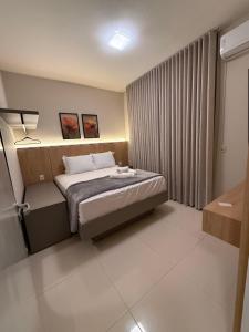 a hotel room with a bed and a window at Apto Mais Decor 02 in Salinas
