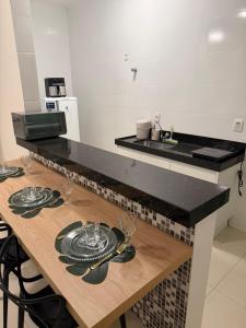 a kitchen with a table with plates and wine glasses at Apto Mais Decor 02 in Salinas