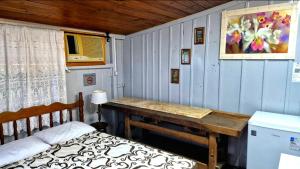 a bedroom with a wooden table and a bed at Pousada Vino & Leta O seu parador no centro in Grão Pará