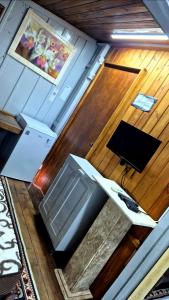 a living room with a tv and a table at Pousada Vino & Leta O seu parador no centro in Grão Pará