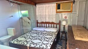 a small bedroom with a bed and a toilet at Pousada Vino & Leta O seu parador no centro in Grão Pará