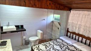 a small bathroom with a bed and a sink at Pousada Vino & Leta O seu parador no centro in Grão Pará