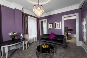 a living room with purple walls and a couch and a table at Midlands Park Hotel in Portlaoise