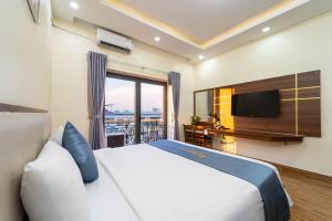 a bedroom with a large bed and a television at Winston Hotel Riverside in Ho Chi Minh City