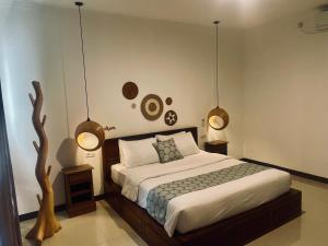 a bedroom with a bed with two lamps on the wall at Selong Holiday in Selong Belanak +79 photos