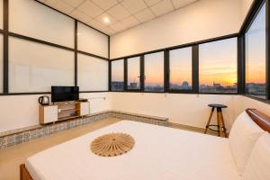a room with windows and a table with a television at Yoyo Airport Saigon Hotel in Ho Chi Minh City