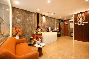 a lobby with a couch and a table and a counter at Yoyo Airport Saigon Hotel in Ho Chi Minh City