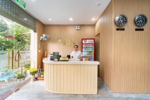 a woman sitting at a counter in a restaurant at Winston Hotel Riverside in Ho Chi Minh City