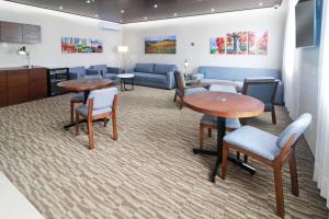 a waiting room with tables and chairs and a couch at Staybridge Suites Queretaro by IHG in Querétaro