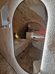 a room with a bed and a tub in a cave at Soffio di Pietra in Castellana Grotte +15 photos