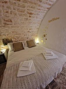 a bedroom with a bed with two towels on it at Soffio di Pietra in Castellana Grotte