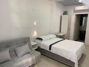 a bedroom with a bed and a couch at Hotel La Cima in Arboletes