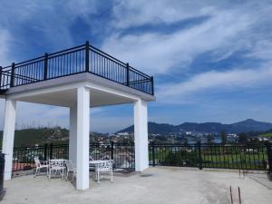 a gazebo with tables and chairs on a balcony at AGP home in Nuwara Eliya