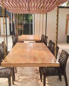 a large wooden table with chairs around it at Wanderlust Beach Villa in Agatti