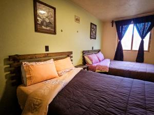 a bedroom with two beds and a window at SiempreViva Hospedaje By GEstores in Chignahuapan