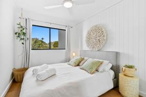 a white bedroom with a bed with towels on it at Pacific Place Apartments in Gold Coast +137 photos