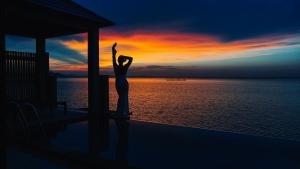 a woman standing on the side of a building with her hands in the air at Vedana Lagoon Resort & Spa in Hue