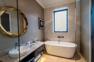 a bathroom with a tub and a sink and a mirror at Midlands Park Hotel in Portlaoise