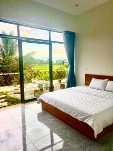 a bedroom with a bed and a large window at Mường Thanh Garden Stay in Dien Bien Phu