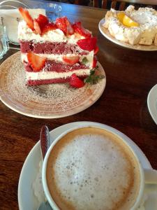 a table with two plates of cake and a cup of coffee at El Espinillo 2 in La Falda