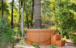 a garden with a wooden fence and a tree at Tiny House 10 Met Hottub in Wenum