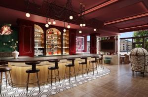a bar with bar stools in a room at Hotel Indigo Dallas Downtown by IHG in Dallas