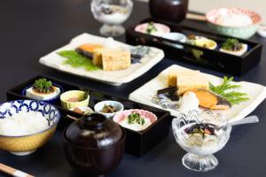 a table topped with plates of food and bowls of sushi at Ryokan Hakura in Yamanouchi