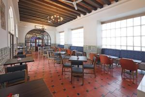 a dining room with tables and chairs and windows at Holiday Inn Express Veracruz Centro Historico by IHG in Veracruz
