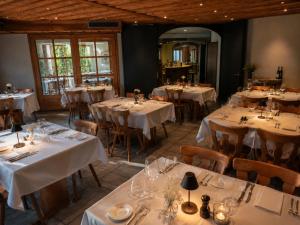 ein Esszimmer mit Tischen und Stühlen mit weißen Tischdecken in der Unterkunft Alpine Hotel Reich in Cazis