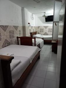 a room with two beds and a bathroom at Hotel La Palma Girardot in Girardot
