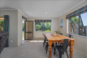 a dining room with a wooden table and chairs at Family Friendly-Whitianga in Whitianga