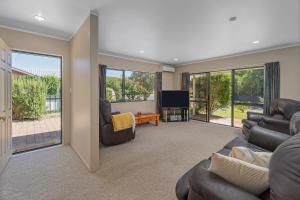 a living room with a couch and a television at Family Friendly-Whitianga in Whitianga +12 photos