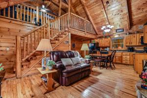 a living room with a couch and a staircase in a cabin at Mountain Joy cabin in Gatlinburg +30 photos