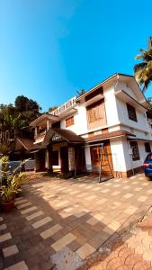 a large white house with a parking lot at Coffeehut Pool Villa in Pinangode