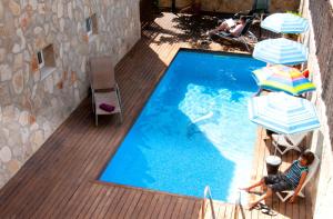 an overhead view of a swimming pool with two people and umbrellas at Hotel Marbel in Cala Ratjada