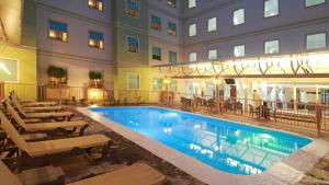 a swimming pool in front of a building with a hotel at Staybridge Suites Queretaro by IHG in Querétaro