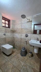 a bathroom with a toilet and a sink at Coffeehut Pool Villa in Pinangode +10 photos