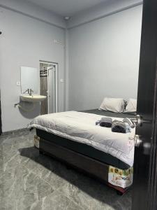 a bedroom with a bed and a sink in it at Teupin Layeu Hotel in Iboih