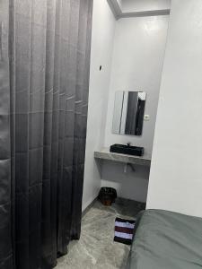 a bedroom with a shower curtain and a mirror at Teupin Layeu Hotel in Iboih