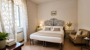 a bedroom with a large bed and a chair at Casa Giusto Ischia in Ischia Town