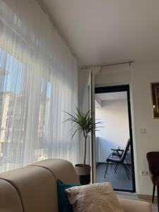 ein Wohnzimmer mit Sofa und Fenster in der Unterkunft Petica in Brčko