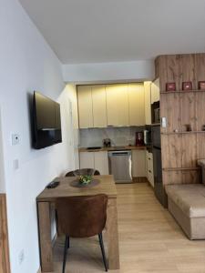 ein Wohnzimmer mit kleinem Tisch und eine Küche in der Unterkunft Petica in Brčko